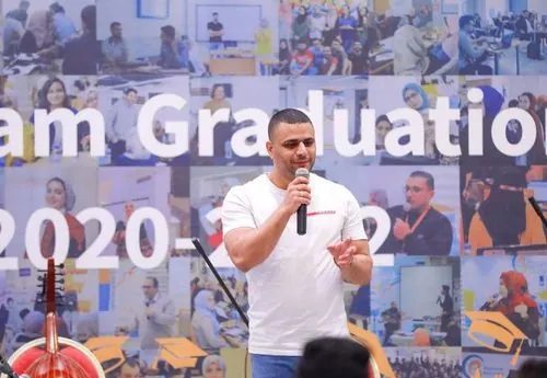 Adnan on stage sharing his success story at a Gaza Sky Geeks graduation